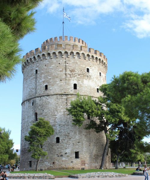 Historic White Tower in Thessaloniki with lush greenery and clear sky